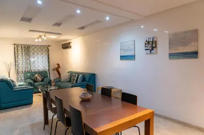 a dining room with a table and chairs at Two Bedroom Luxury Appt with air conditioning parking and pool in Marrakech