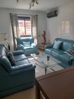 a living room with blue couches and a glass table at Two Bedroom Luxury Appt with air conditioning parking and pool in Marrakech
