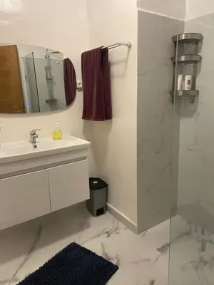 a bathroom with a sink and a shower with a mirror at 4-person apartment Guéliz Blida in Marrakech