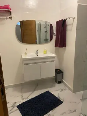 a bathroom with a sink and a mirror and a rug at 4-person apartment Guéliz Blida in Marrakech