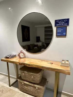 a mirror on a wall with a wooden table at le CHARM J40 en face CTM Hivernage a 15mn de l'aéroport in Marrakech