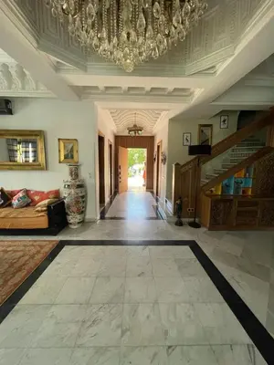 a large living room with a chandelier and a hallway at Villa Souzana in Marrakech
