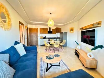 a living room with a blue couch and a table at Le Cosy de Gueliz avec Piscine et Belle Vue in Marrakech