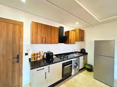 a kitchen with a stove and a refrigerator at Le Cosy de Gueliz avec Piscine et Belle Vue in Marrakech