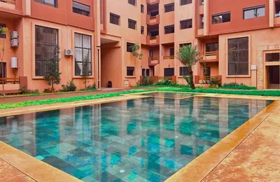 a swimming pool in front of a building at Le Cosy de Gueliz avec Piscine et Belle Vue in Marrakech