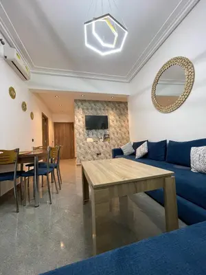 a living room with a blue couch and a table at Marrakech Center Getaway Apartment in Marrakech