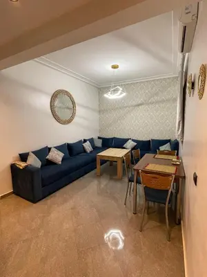 a living room with a blue couch and a table at Marrakech Center Getaway Apartment in Marrakech