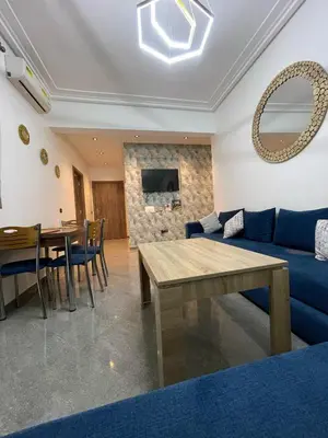 a living room with a blue couch and a table at Marrakech Center Getaway Apartment in Marrakech