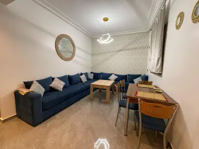 a living room with a blue couch and a table at Marrakech Center Getaway Apartment in Marrakech