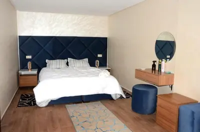 a bedroom with a large bed with a blue headboard at Burj malak in Marrakech