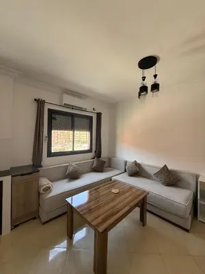 a living room with a couch and a table at charming apartment close to airport Marrakech in Marrakech