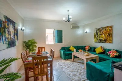 a living room with a green couch and a table at Spacious and Family Apartment in Marrakech
