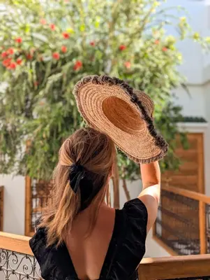a woman wearing a straw hat on her head at Riad Doll LallaZwina in Marrakech