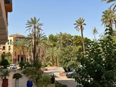 a parking lot with palm trees and a car at Exclusive Luxury Stay with Pool, Jacuzzi and Service in Marrakech