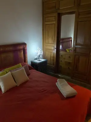 a bedroom with a bed with a red blanket and a dresser at SEJOUR D'EXCEPTION LUXE Et SERENITE MARRAKECH in Marrakech