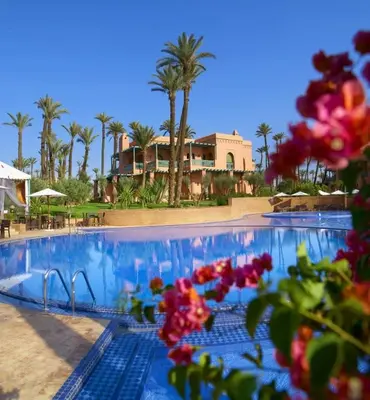 a swimming pool with palm trees and a resort at SEJOUR D'EXCEPTION LUXE Et SERENITE MARRAKECH in Marrakech