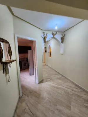 a hallway with white walls and a ceiling with antlers at Appartement de luxe in Marrakech