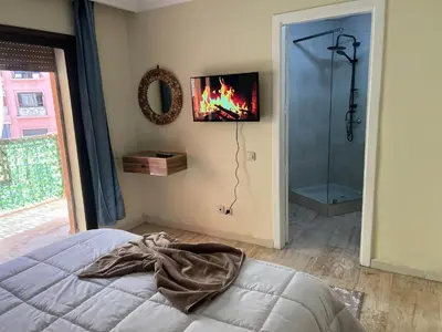 a bedroom with a bed and a tv on the wall at Appartement de luxe in Marrakech