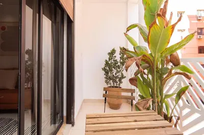 a balcony with plants and a wooden bench at Terra Cotta Suite, Luxe & Relaxing Bath in Marrakech