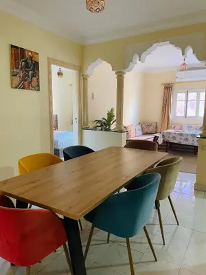 a dining room with a wooden table and chairs at Appartement charmant à 5 min de Gueliz in Marrakech
