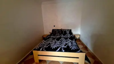 a small bed with a black and white blanket on it at Appartement Studio Sejourkech, Gueliz Plaza in Marrakech