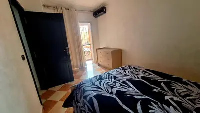 a bedroom with a bed and a dresser and a door at Appartement Studio Sejourkech, Gueliz Plaza in Marrakech