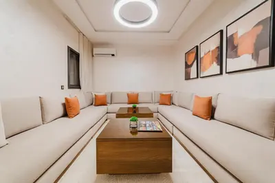 a living room with a white couch and a table at Modern Appart , Parking , Pool & Fiber wifi , Hivernage City Centre in Marrakech
