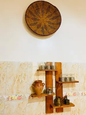a kitchen with wooden shelves and a clock on the wall at Cozy Moroccan-style apartment in Marrakech