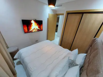 a bedroom with a bed and a fire painting on the wall at Appartement centre ville marrakech in Marrakech