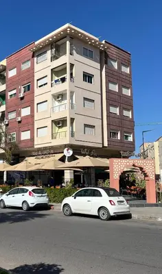 two white cars parked in front of a building at حي الشرف in Marrakech