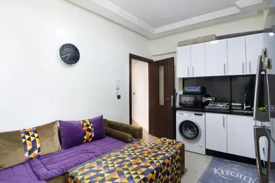 a living room with a purple couch and a kitchen at حي الشرف in Marrakech