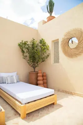 a bedroom with a bed and a potted plant at Riad À l'ombre des Orangers in Marrakech