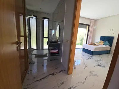 a bedroom with a marble floor with a bed and a mirror at Villa echwitter in Marrakech