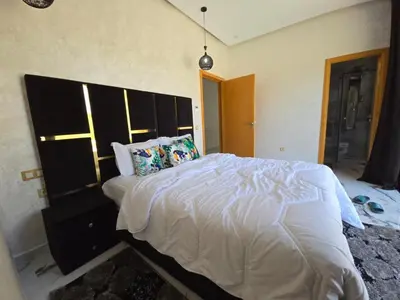 a bedroom with a large bed with a large headboard at Villa echwitter in Marrakech