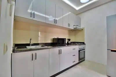 a kitchen with white cabinets and a sink at Central and Cozy Gem Balcony in Marrakech