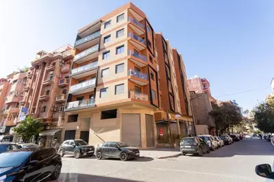 a tall building on a city street with parked cars at Central and Cozy Gem Balcony in Marrakech