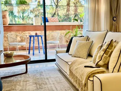 a living room with a white couch and a table at Yves Saint Laurent Jacuzzi Elegance in Marrakech