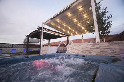 a hot tub in a backyard with a pergola at Marrakech River Palm in Dar Caïd Layadi