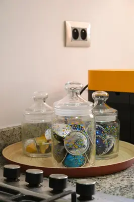 two glass jars on a tray with plates and dishes at Luxury 2BD in Prestigia Jade with Pool and Golf View in Marrakech