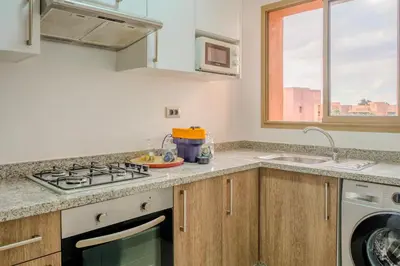 a kitchen with a stove and a sink and a window at Luxury 2BD in Prestigia Jade with Pool and Golf View in Marrakech