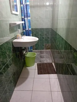 a green tiled bathroom with a sink and a shower at big house with swiming pool in Marrakech