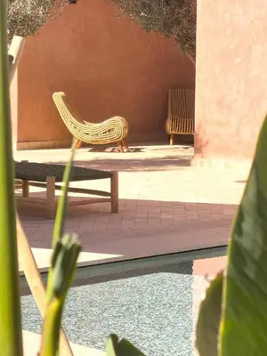a yellow chair sitting on a patio next to a building at Villa à Marrakech 8 Personnes, Piscine et Petits-Déjeuners Inclus in Sraghna