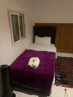 a bed with a purple blanket with a hat on it at Maison Mariam in Marrakech