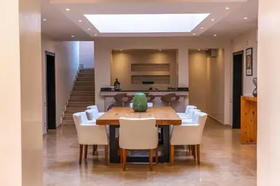 a dining room with a table and white chairs at Villa Anna - Havre de paix in Oulad Ikhia
