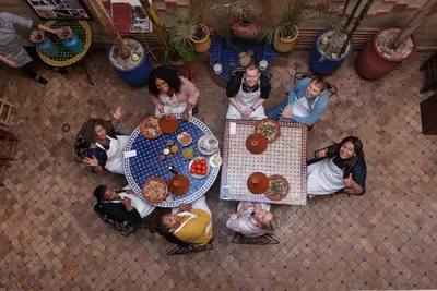 a group of people sitting around a table with food at Riad Thycas in Marrakech