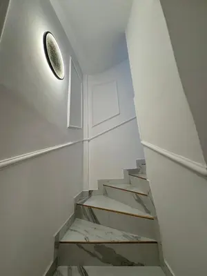 a staircase in a white room with a circular light at Beautiful new modern house with full comfort in Marrakech