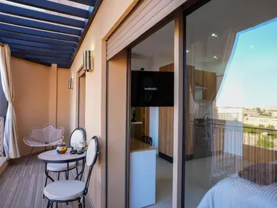 a room with a balcony with a table and chairs at Suite Sofia Suite avec superbe terrasse Gueliz in Marrakech