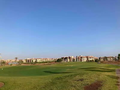 a view of a golf green with buildings in the background at Beautiful residence with pools inMarrakech Golf City in Marrakech
