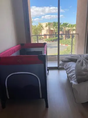 a bedroom with a bed and a large window at Beautiful residence with pools inMarrakech Golf City in Marrakech