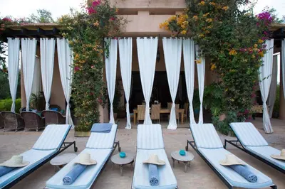 a group of chaise lounges with hats and tables at Dar abie in Sraghna